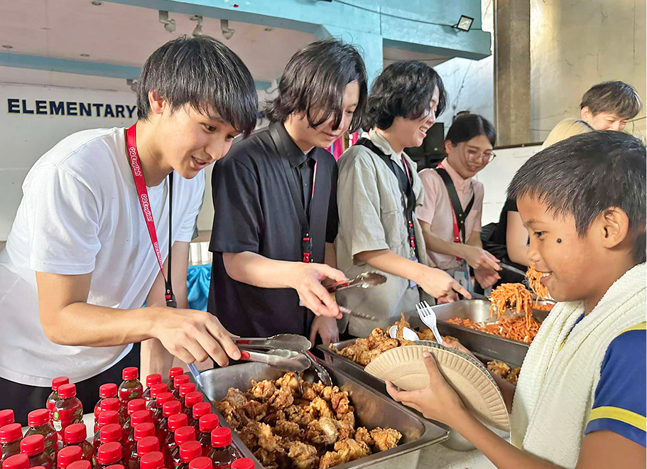 フィリピンの子ども達へ食事配膳をしている様子
