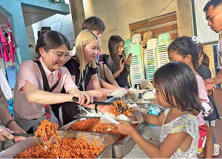 フィリピンの子ども達へ食事を配膳している様子